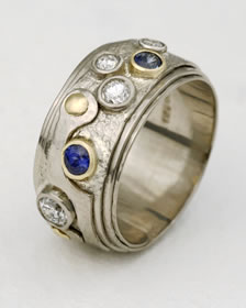 White gold coiled ring with four diamonds and two Sapphires
